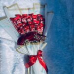 Red Velvet is a thoughtfully designed bouquet that blends classic romance with modern elegance. Featuring rich red roses paired with premium chocolate accents, this arrangement is wrapped in soft ivory tones and finished with a refined red ribbon for a polished look. Ideal for anniversaries, celebrations, and meaningful surprises, Red Velvet is crafted to express love, warmth, and appreciation in a sophisticated way. A perfect choice for those who value quality, beauty, and timeless style.